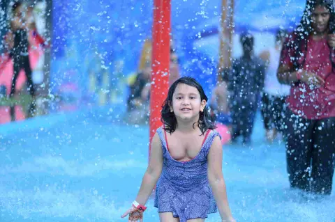 Child playing in the rain dance splash zone