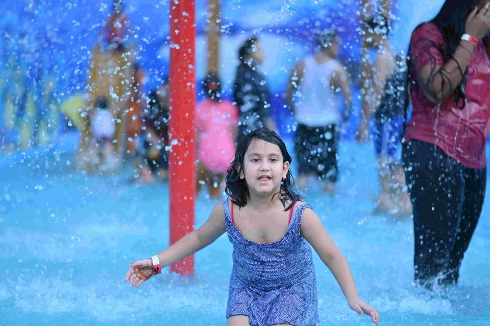 Little girl running through the spray in the kids splash zone